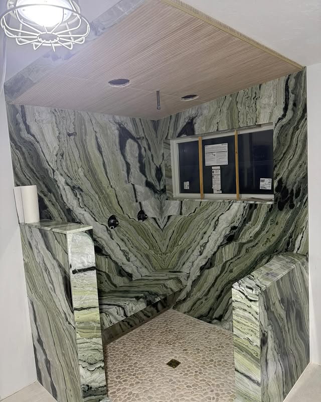 Book-matched green marble steam shower with pebble floor