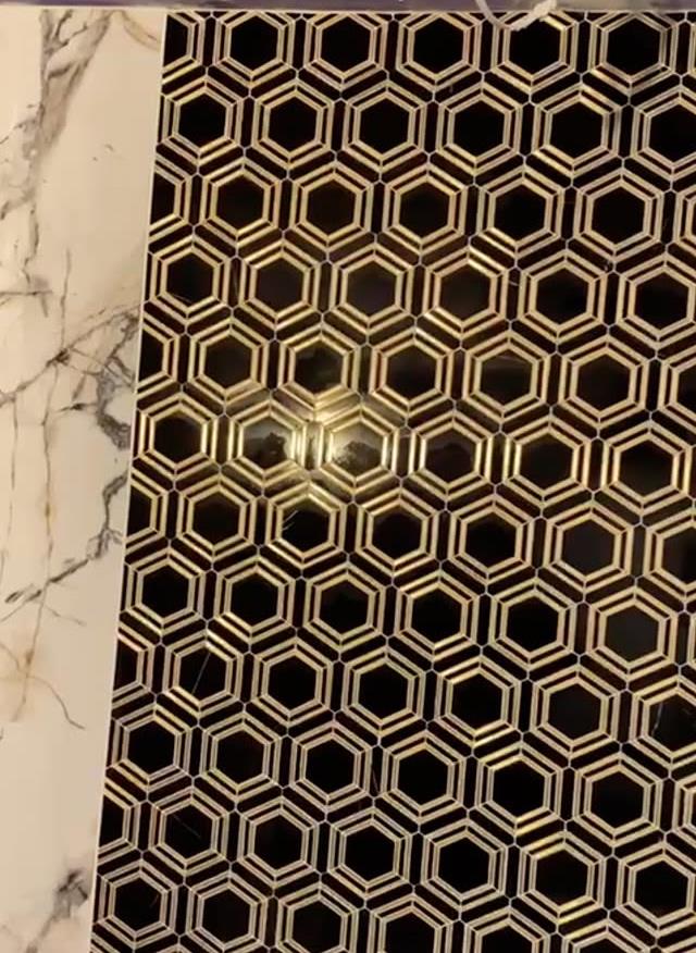 Black and gold hexagon mosaic feature next to Calacatta marble